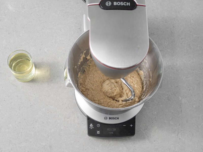 Wyrabianie ciasta drożdżowego. Obok w szklance olej rzepakowy.