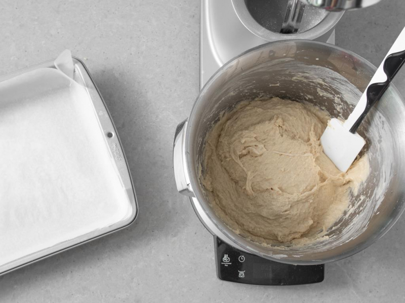 Ponownie zagniecione ciasto drożdżowe w misie. Obok