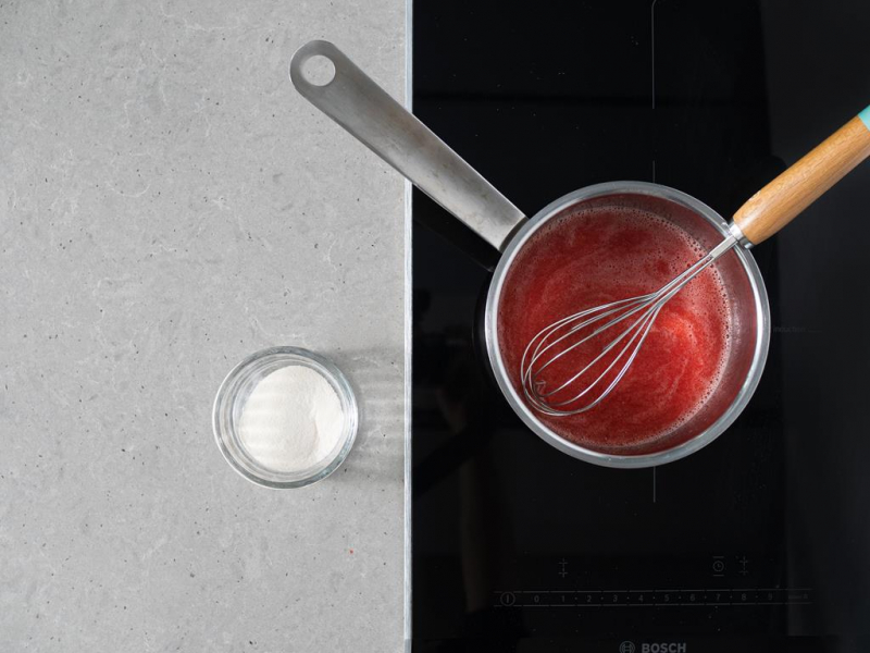 Mus z truskawek z garnku. Obok agar w szklanej miseczce.