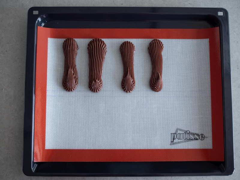 na blasze z matą silikonowej kakaowe eklerki przed pieczeniem