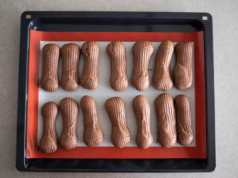 upieczone kakaowe eklerki na blaszce z matą sylikonową
