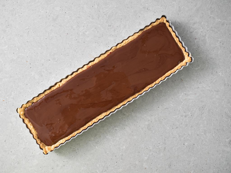 Wegański ganache przelany na wegańską tartę.