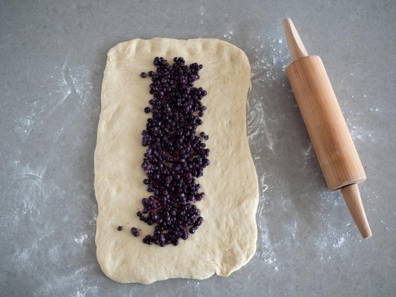 rozwałkowane ciasto drożdżowe z jagodami