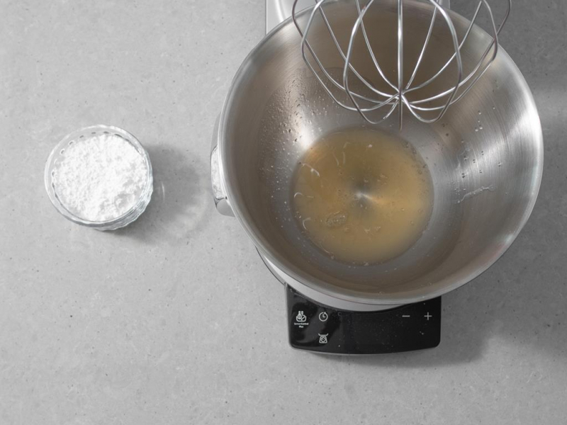 Aquafaba w misie, a obok cukier puder.