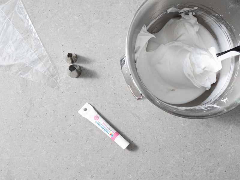 W misie ubita wegańska beza. Obok worek cukierniczy, tylki i różowy barwnik.