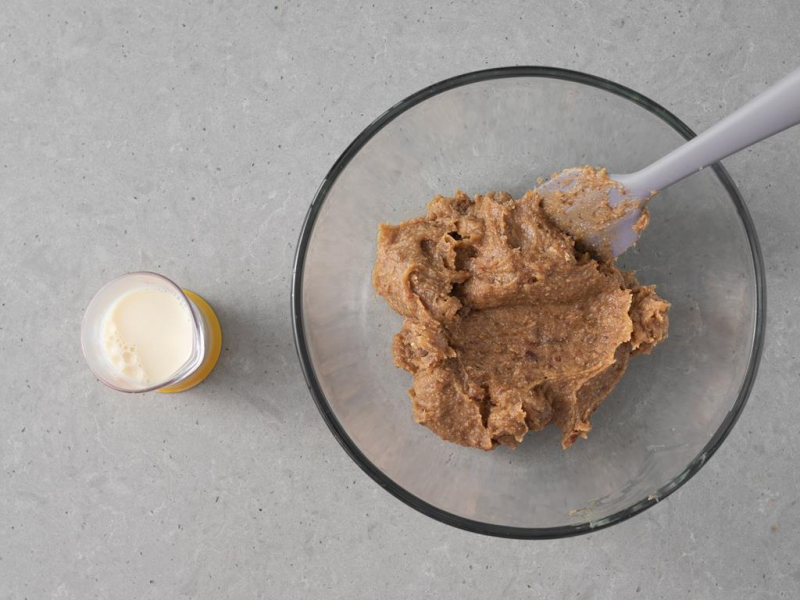 Masa daktylowo-orzechowa w misce. Obok napój owsiany.