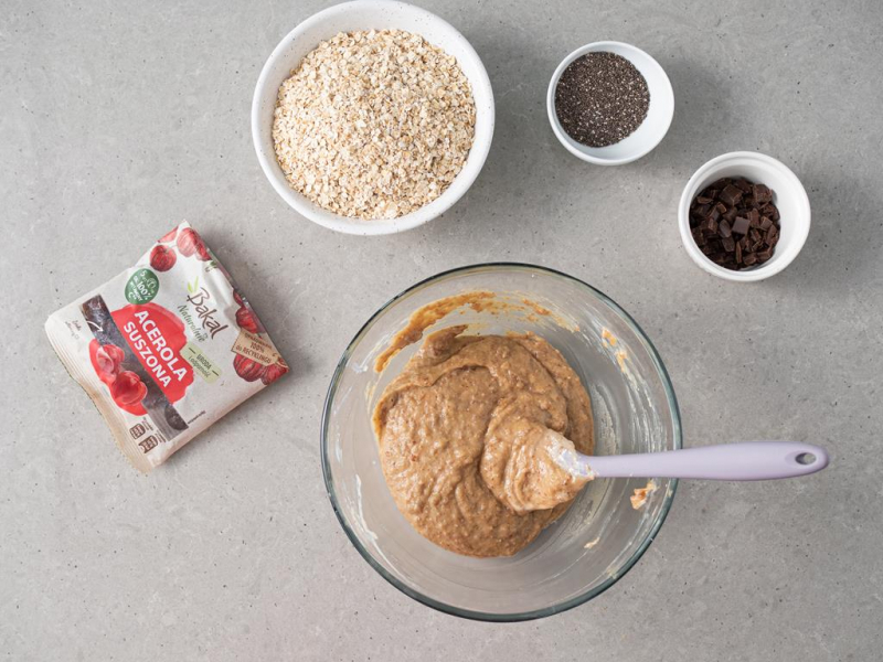 W misie masa daktylowo-orzechowa. Obok miseczka z płatkami owsianymi, nasionami chia, czekoladą oraz suszoną acerolą.