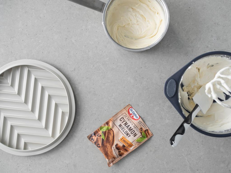 Na blacie cynamon mielony Dr. Oetkera. Obok forma silikonowa z zestawu do tarty Silikomart. W misie ubita 艣mietanka wega艅ska z cukrem pudrem. A w garnku podgrzana 艣mietanka z agarem.