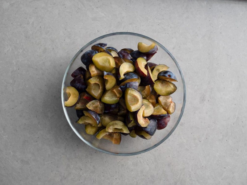 w szklanej miseczce wypestkowane i pokrojone śliwki