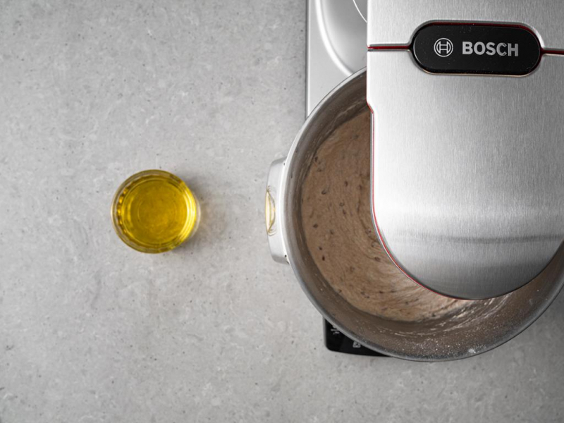 Olej w szklance. Obok wymieszane ciasto w  misie.