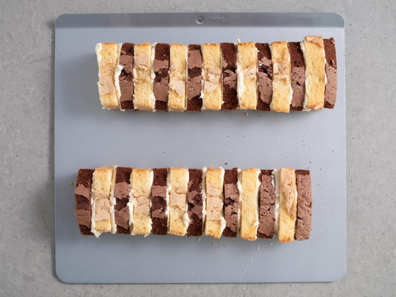 przekładanie kawałków ciasta kremem budyniowym