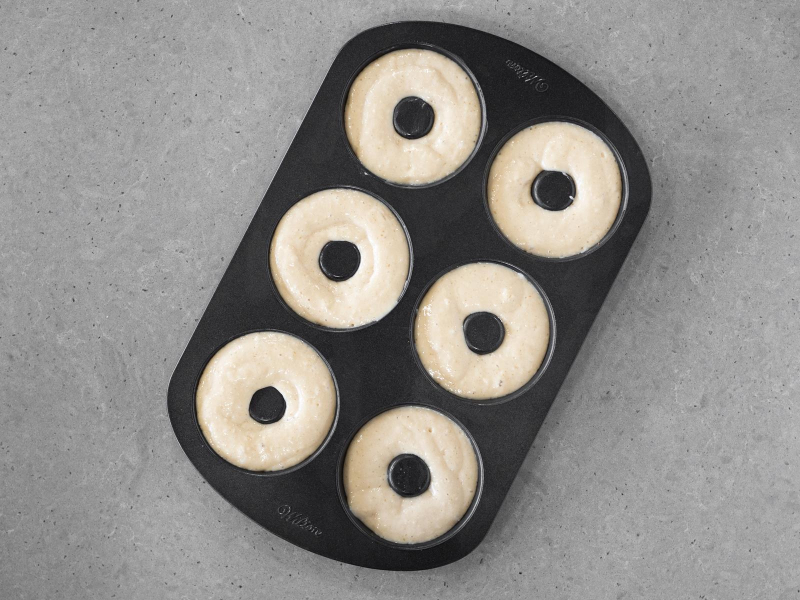 Donuty wegańskie w formie przed pieczeniem.