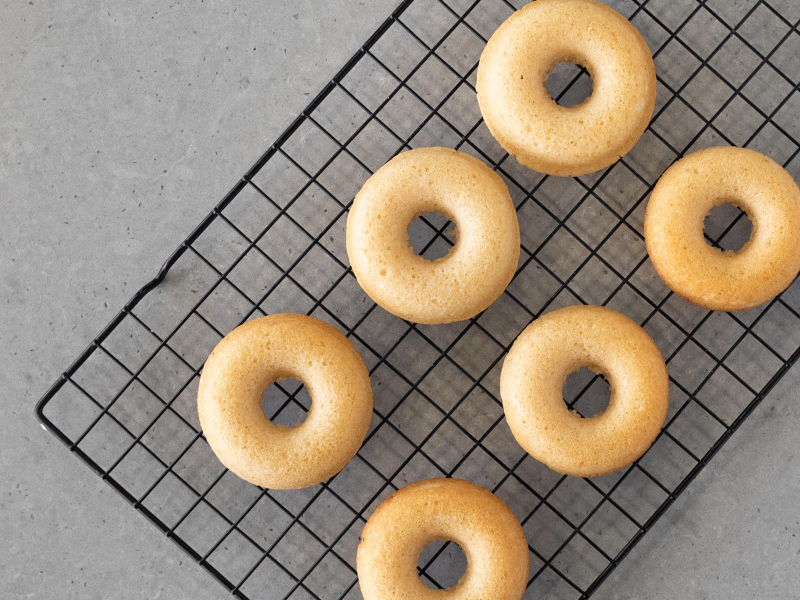 Upieczone wegańskie donuty bez mleka i jajek na kratce do studzenia.