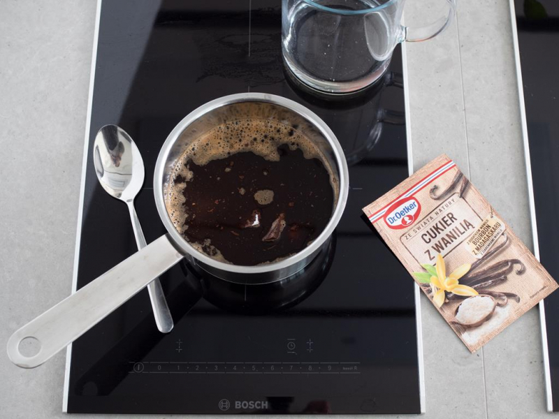 w rondelku na płycie indukcyjnej masa czekoladowa obok cukier z wanilią Dr. Oetkera