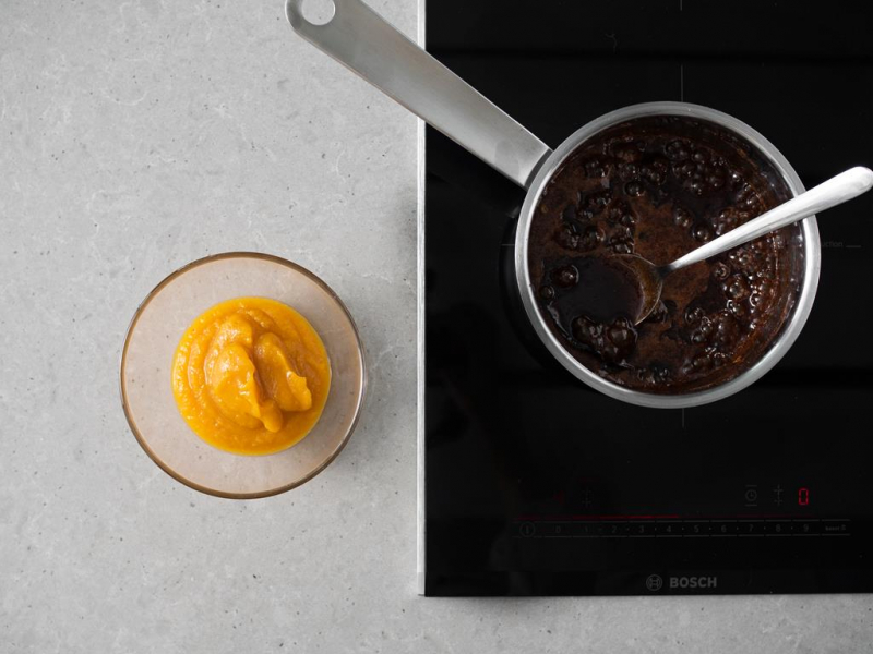W misce puree z dyni. Obok w garnku gotujący się syrop z przyprawami korzennymi.
