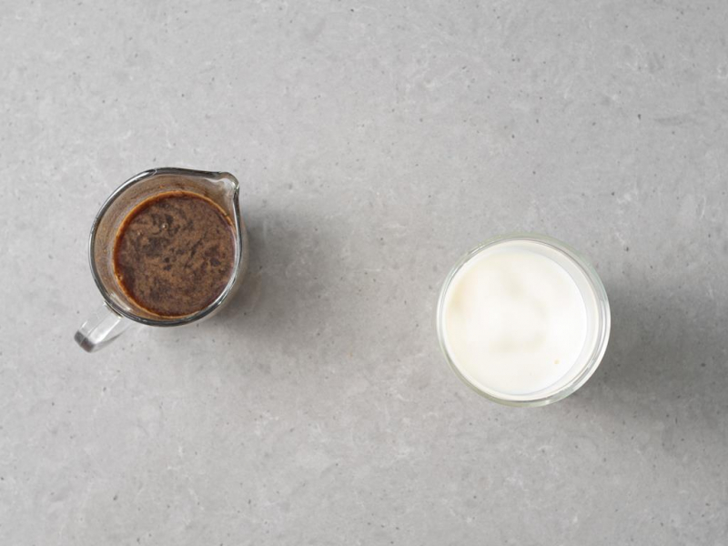 W dzbanku podwójne espresso wymieszane z syropem dyniowym. Obok spieniony napój roślinny w szklance.