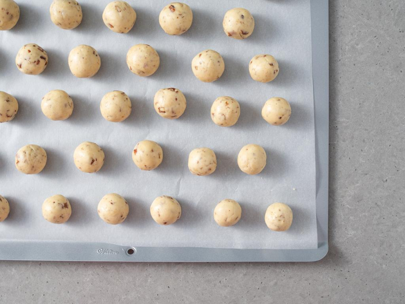 Na blasze do pieczenia ciasteczek rozłożone kulki z ciasta.