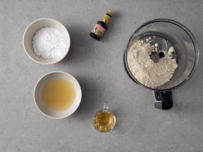 W blenderze mąka migdałowa. Obok ekstrakt naturalny Dr. Oetkera. W miskach cukier puder i aquafaba. A w szklaneczce amaretto.