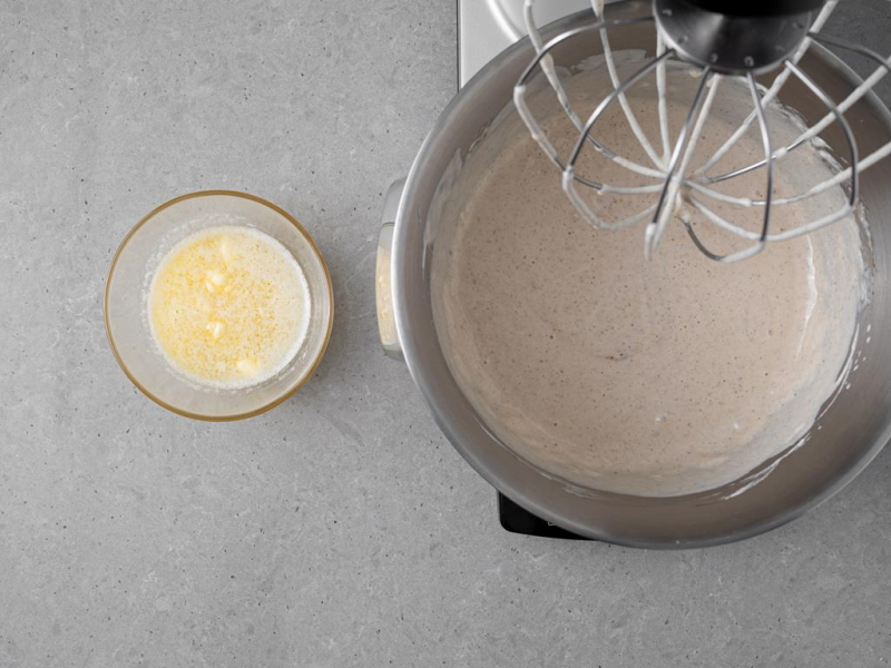 W misie masa serowa, a obok roztopione masło w miseczce.