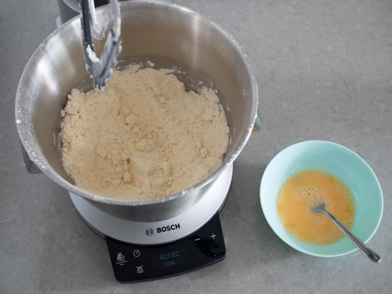 kruszonka na kruche ciasto, obok żółtka w miseczce