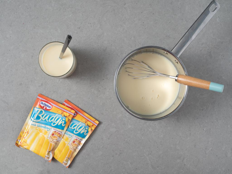 W garnku napój sojowy z cukrem. Obok budynie Dr. Oetkera oraz napój sojowy w szklance.