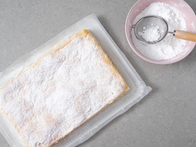 Gotowa napoleonka bez mleka posypana cukrem pudrem.