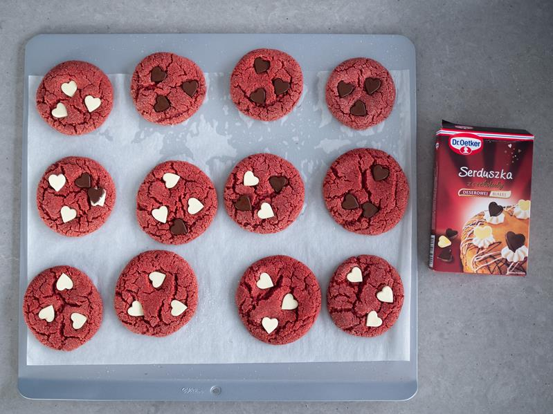 ciasteczka red velvet udekorowane czekoladowymi serduszkami od dr. oetkera, obok opakowanie serduszek z czekolady deserowej i białej