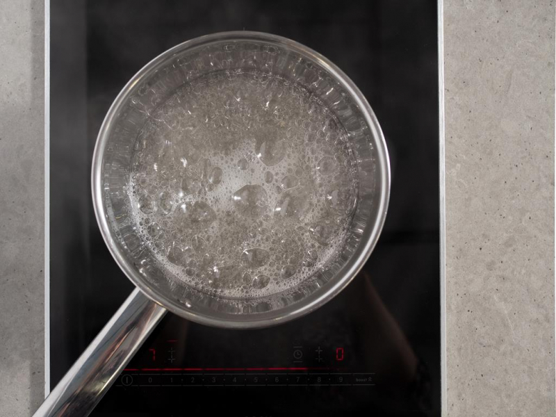 syrop cukrowy do bezowej pianki gotujący się w rondelku na kuchence