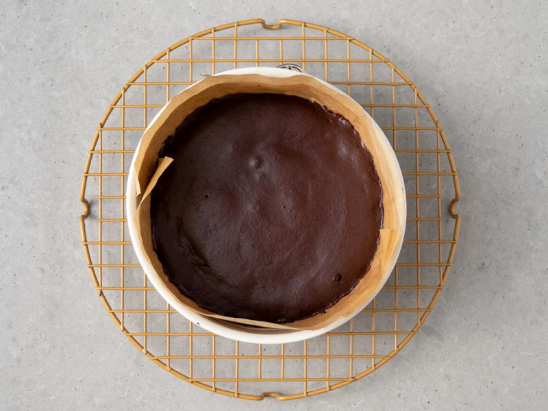 Upieczone ciasto czekoladowe w tortownicy, na kratce do pieczenia.