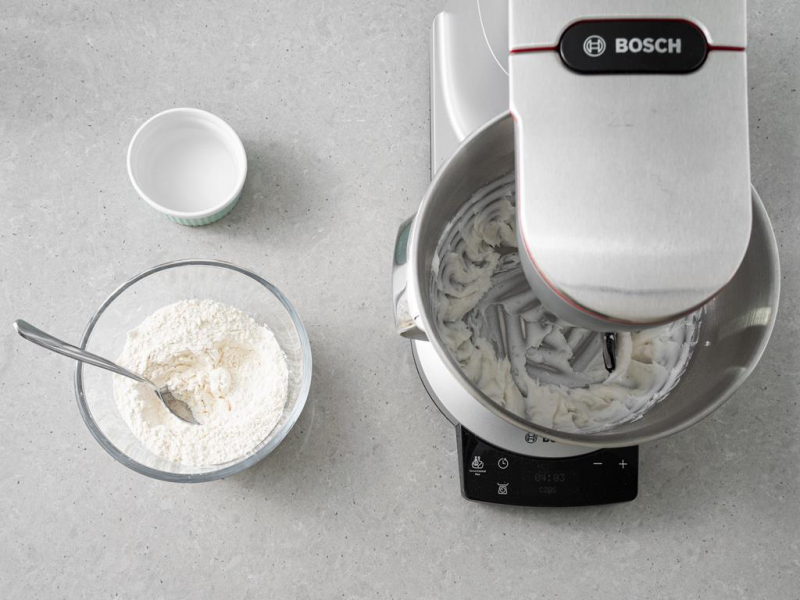 W misie miksera utarty cukier puder z olejem kokosowym. Obok w misie mąka pszenna i sól w miseczce.