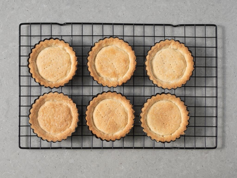Upieczone wegańskie tartaletki na kratce do studzenia.