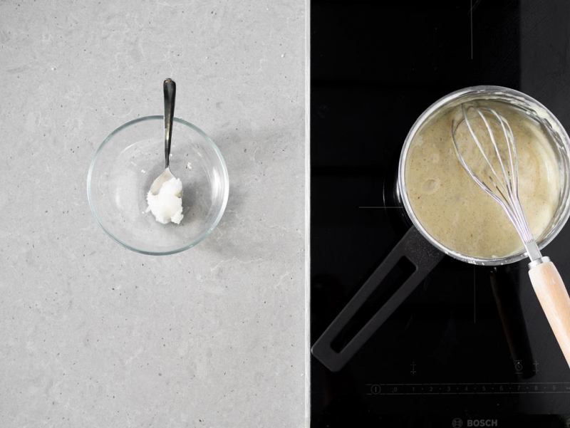 W garnku gotowy waniliowy budyń wegański, a obok olej kokosowy w miseczce.