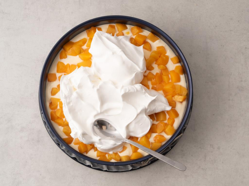 bezowa piana na masie serowej i kawałkach brzoskwiń