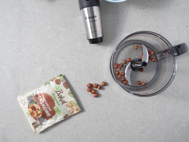 Orzechy laskowe Bakal w opakowaniu. Obok blender ręczny firmy Bosch.