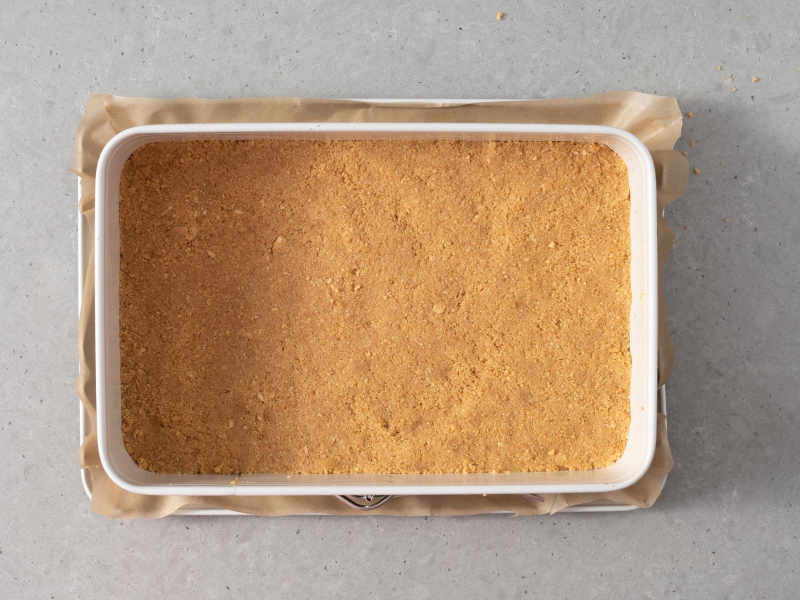 Spód formy wyłożony masą ciasteczkową.