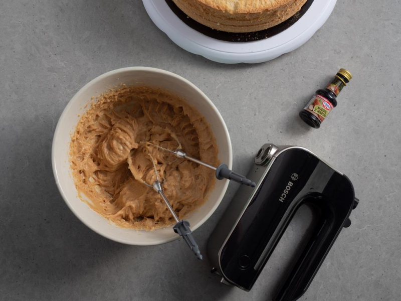 w miseczce zmiksowany krem kajmakowy obok ręczny mikser bosch