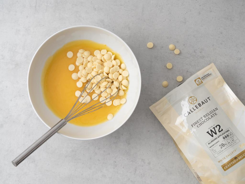 Opakowanie białej czekolady callebaut. Obok w miseczce lemon curd z białą czekoladą