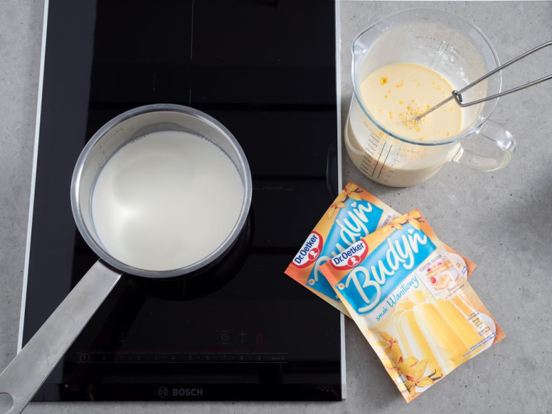 na płycie indukcyjnej bosch rondel z mlekiem i wymieszane budynie dr. oetkera