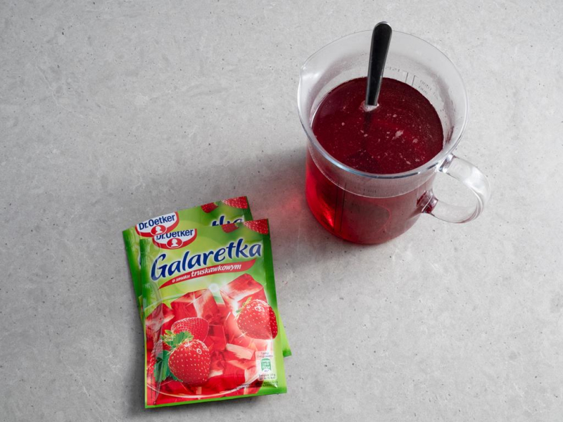 w szklanym naczyniu rozpuszczone galaretki truskawkowe dr.oetker