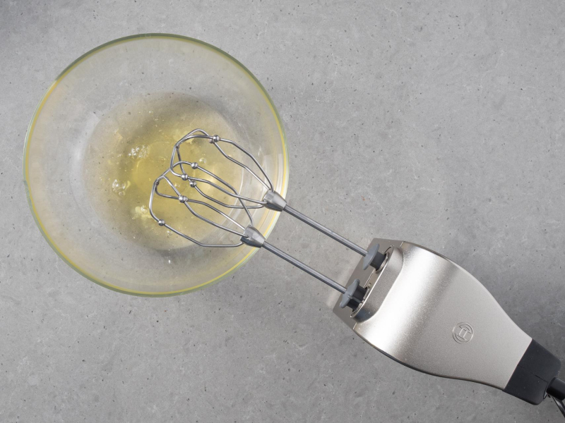 Białka w szklanej misce. Obok mikser ręczny firmy Bosch.