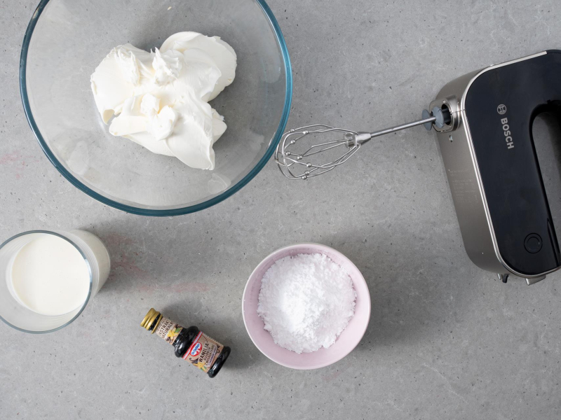 W misce serek mascarpone. Obok w miseczce cukier puder, schłodzona śmietanka i opakowanie ekstraktu waniliowego Dr. Oetkera.