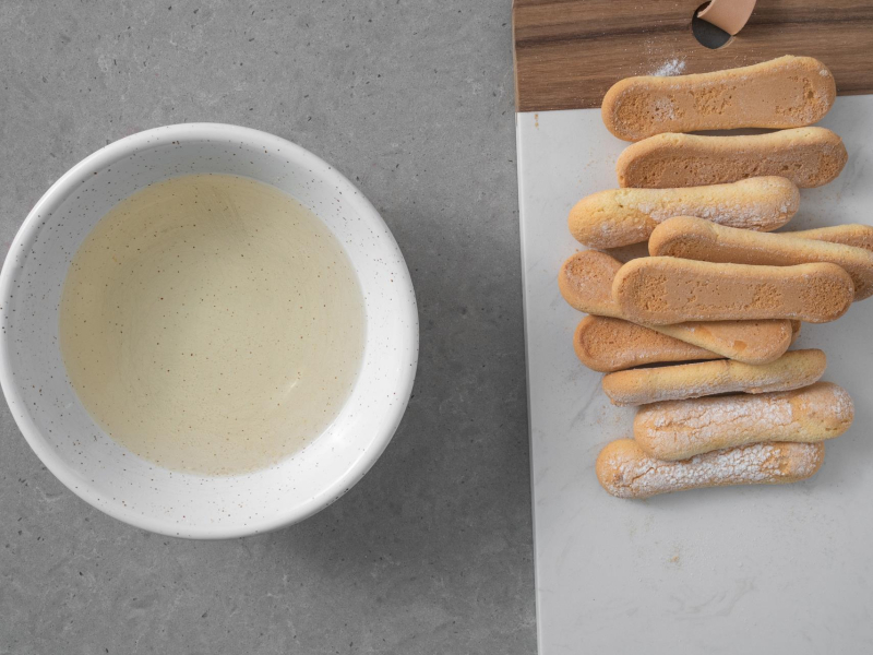 W miseczce prosecco.  Obok na desce biszkopty.