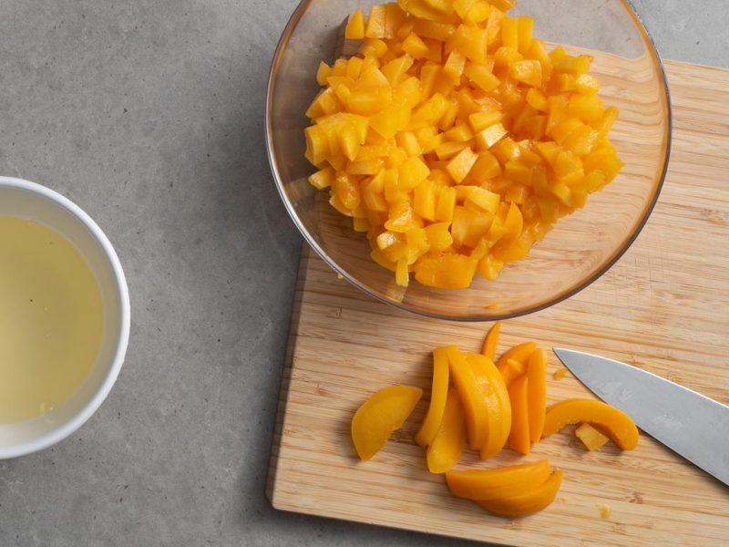 na drewnianej desce pokrojone brzoskwinie z puszki