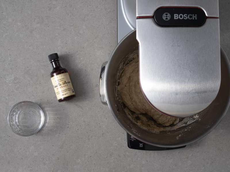Zagniatanie ciasta na pączki w robocie kuchennym. Obok w miseczce spirytus i ekstrakt z wanilii firmy Taylor&Colledge.