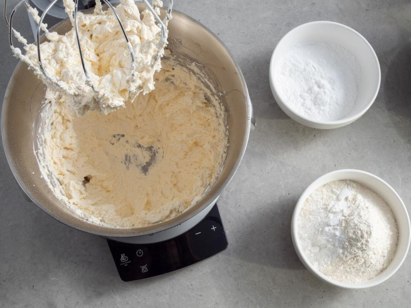 w misie miksera utarte masło obok miseczki z mąką