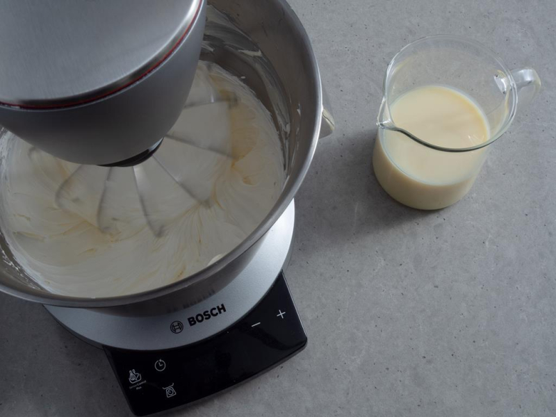 miękkie masło w misie robota bosch obok mleko skondensowane w szklanym naczyniu