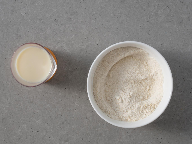 W misie suche wymieszane suche składniki, a w szklance napój sojowy z octem i pastą z wanilii.