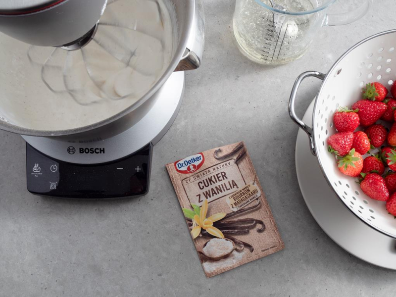 w robocie kuchennym ubijana śmietanka obok cukier z wanilią