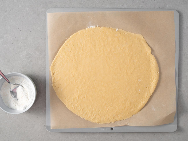 Rozwałkowane ciasto kruche na papierze do pieczenia.