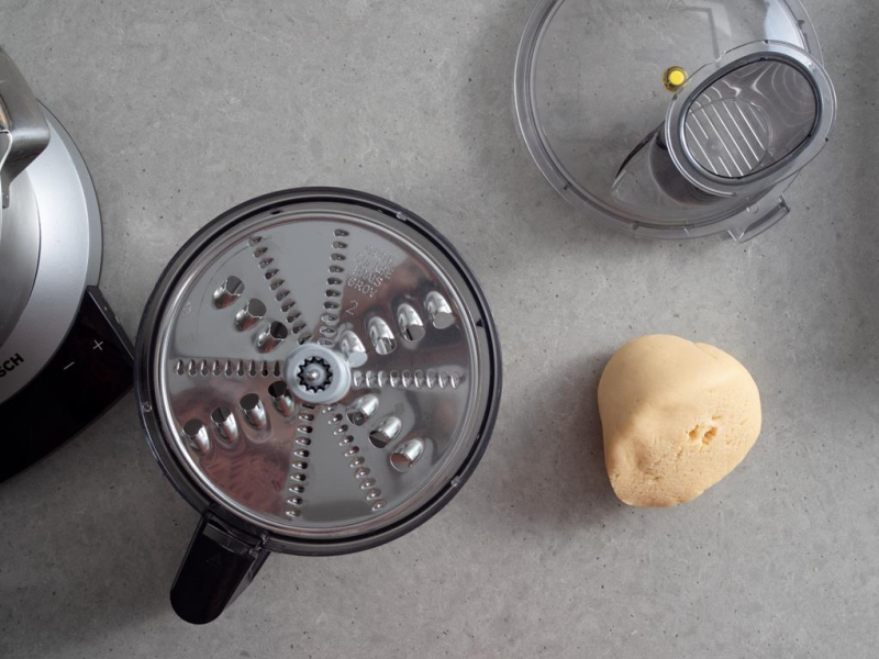 malakser z tarką z dużymi oczkami bosch obok kulka ciasta